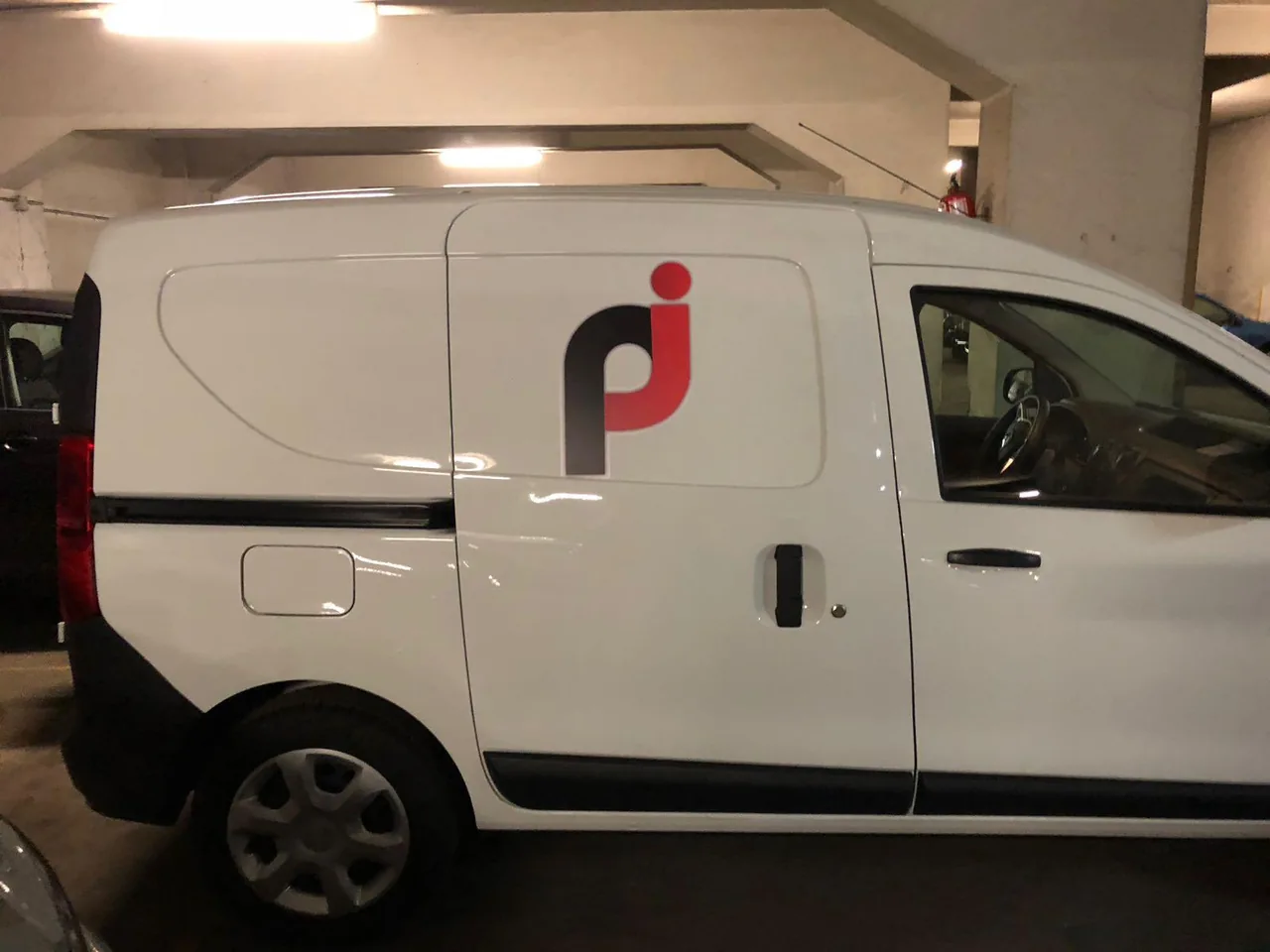 Furgoneta blanca con identidad corporativa aplicada en el lateral